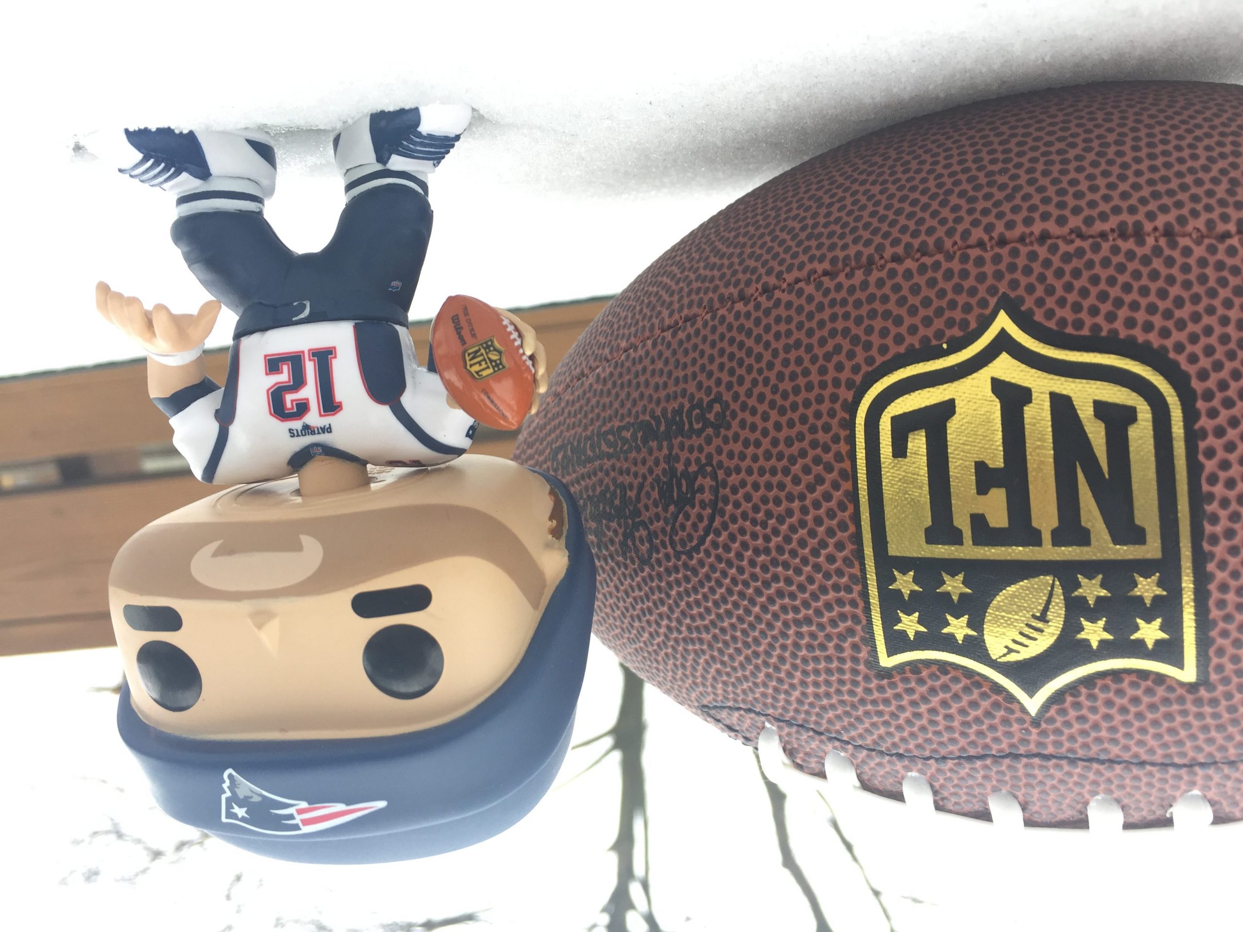 an nfl football and minute figurine of tom brady