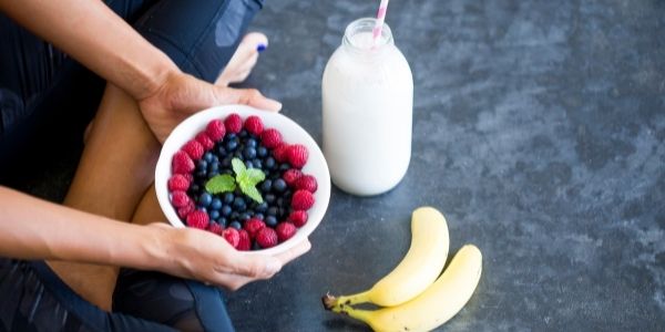 person holding a bowel of fruit