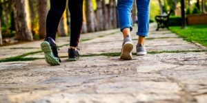 two women walking focused on back of legs and feet